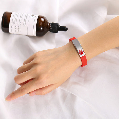 Red medical alert ID bracelet worn on wrist